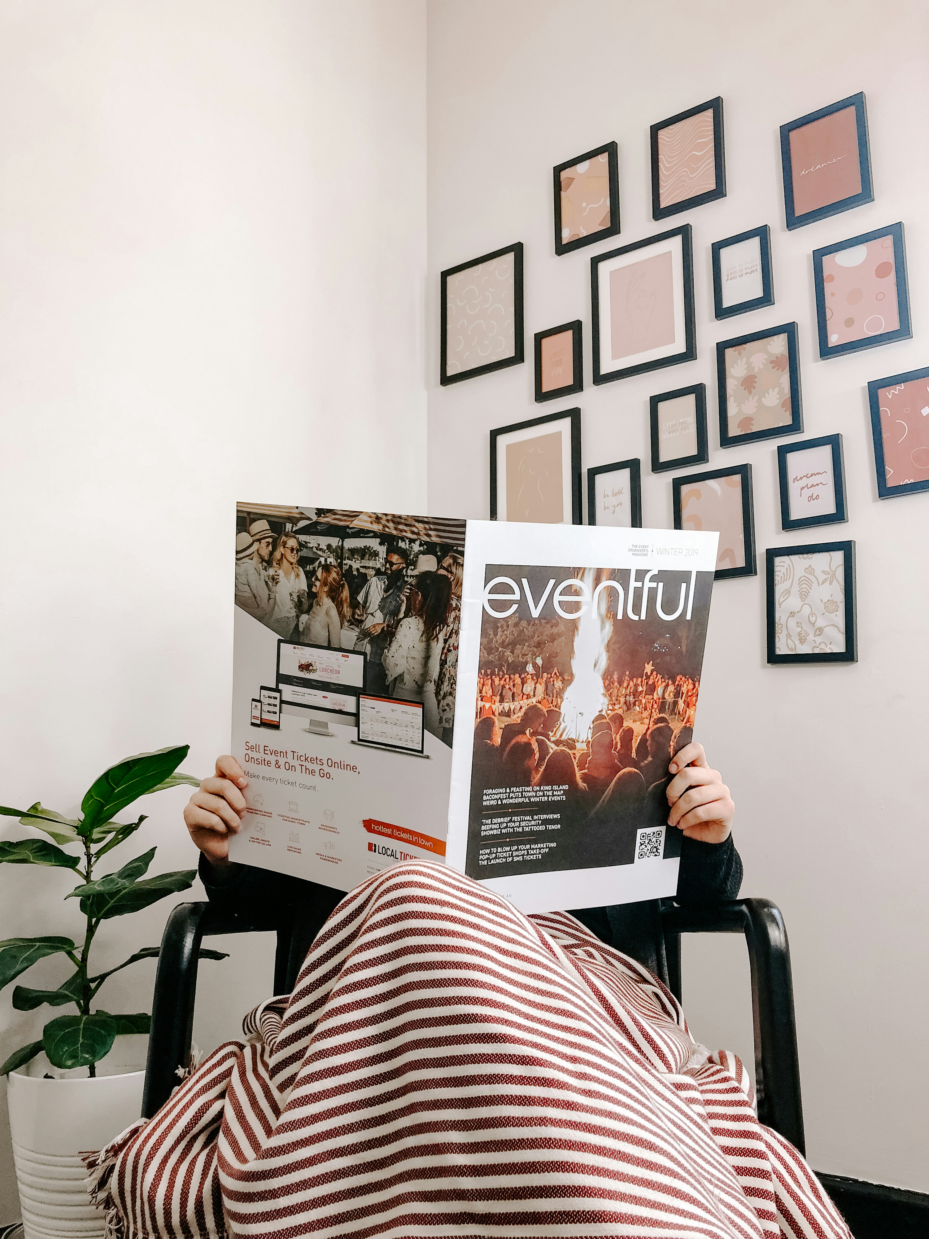 person sitting on armchair reading magazine